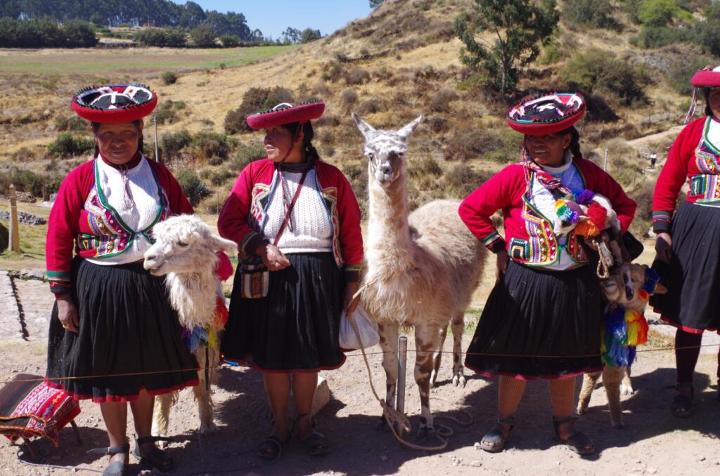 Indígenas qechua con llamas en vestitos tradicionales